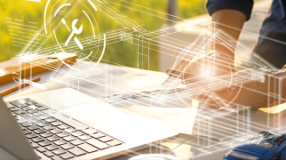 Pessoa trabalhando em projeto digital sobre mesa com notebook aberto, papéis e ferramentas de engenharia, com ícones tecnológicos sobrepostos e campo verde ao fundo.